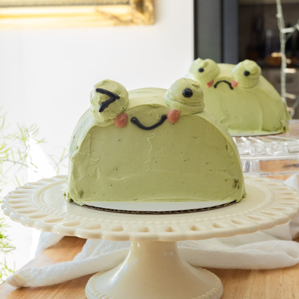 Cute matcha frog cakes on their own cake stands.