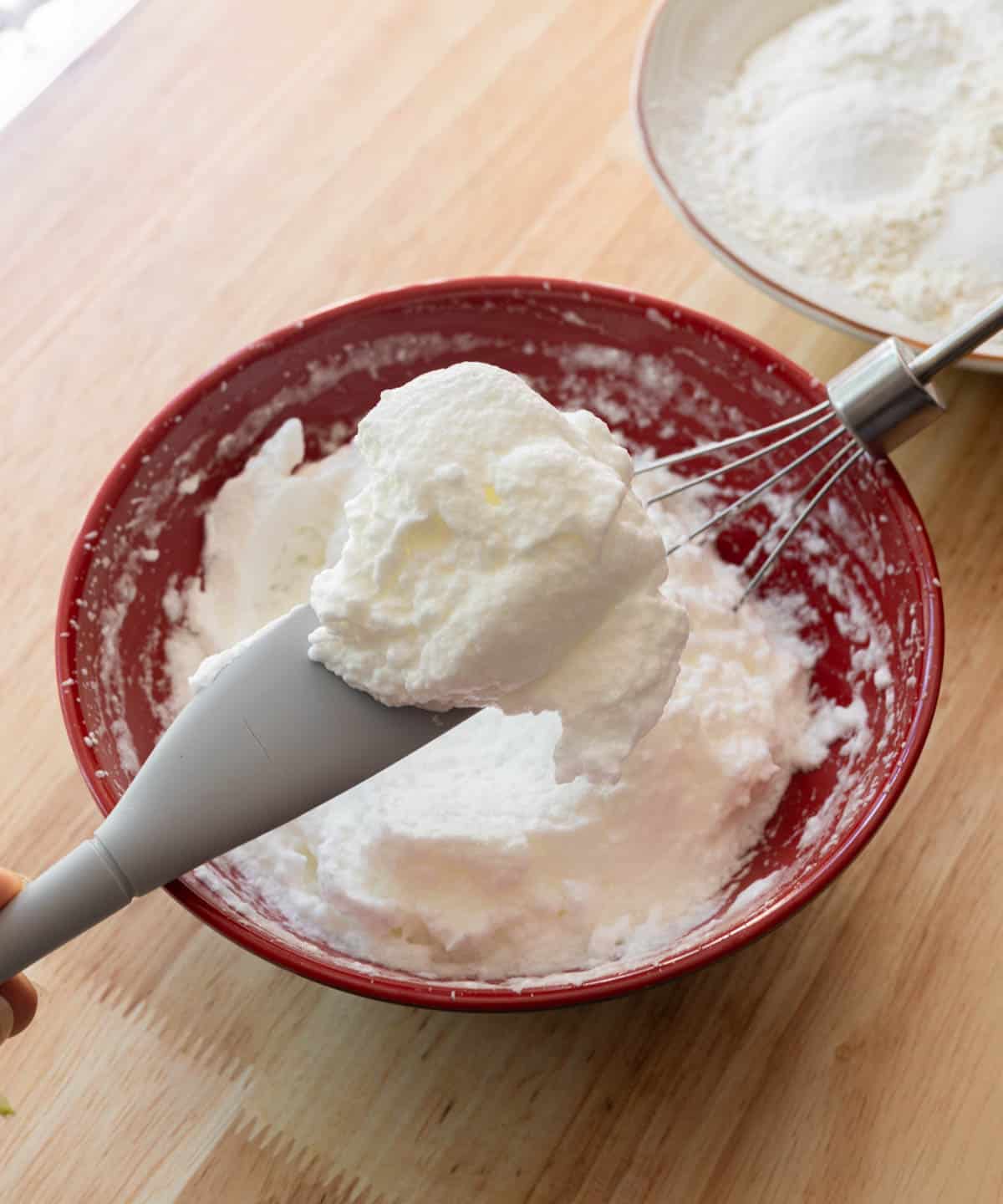 Thick, stiff peak egg whites on a silicone spatula.