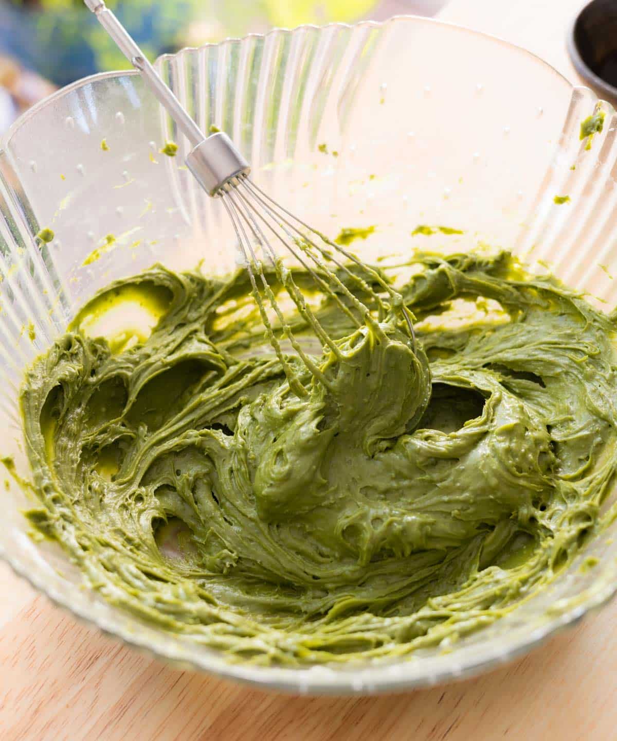 Whipped cream cheese, powdered sugar, and matcha powder in a glass bowl.