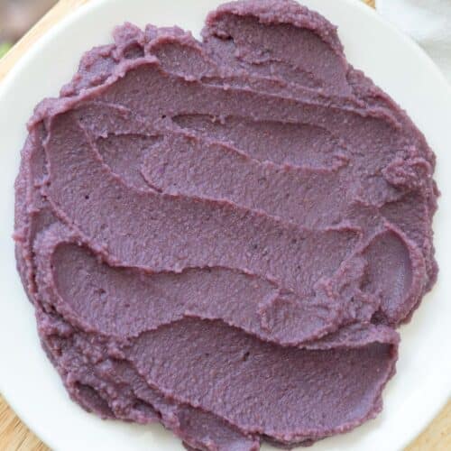 Rehydrated ube powder spread out on a white plate.