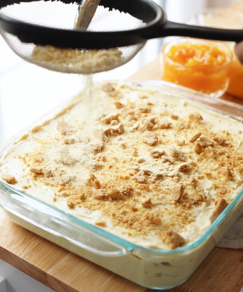 Dusting top of mango icebox cake with freeze dried mango powder.