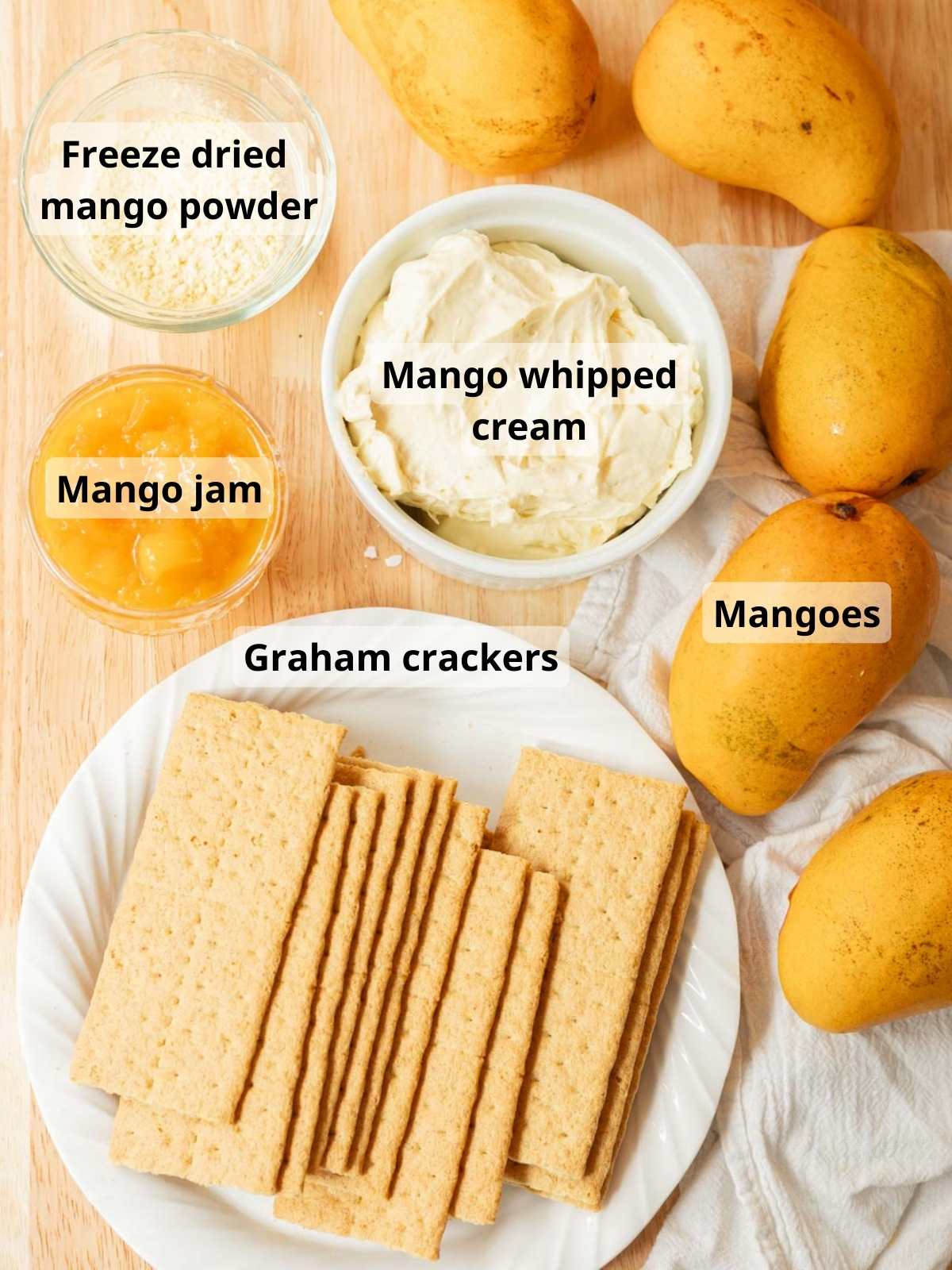 Mango float ingredients laid out on a wooden table, with labels for each ingredient.