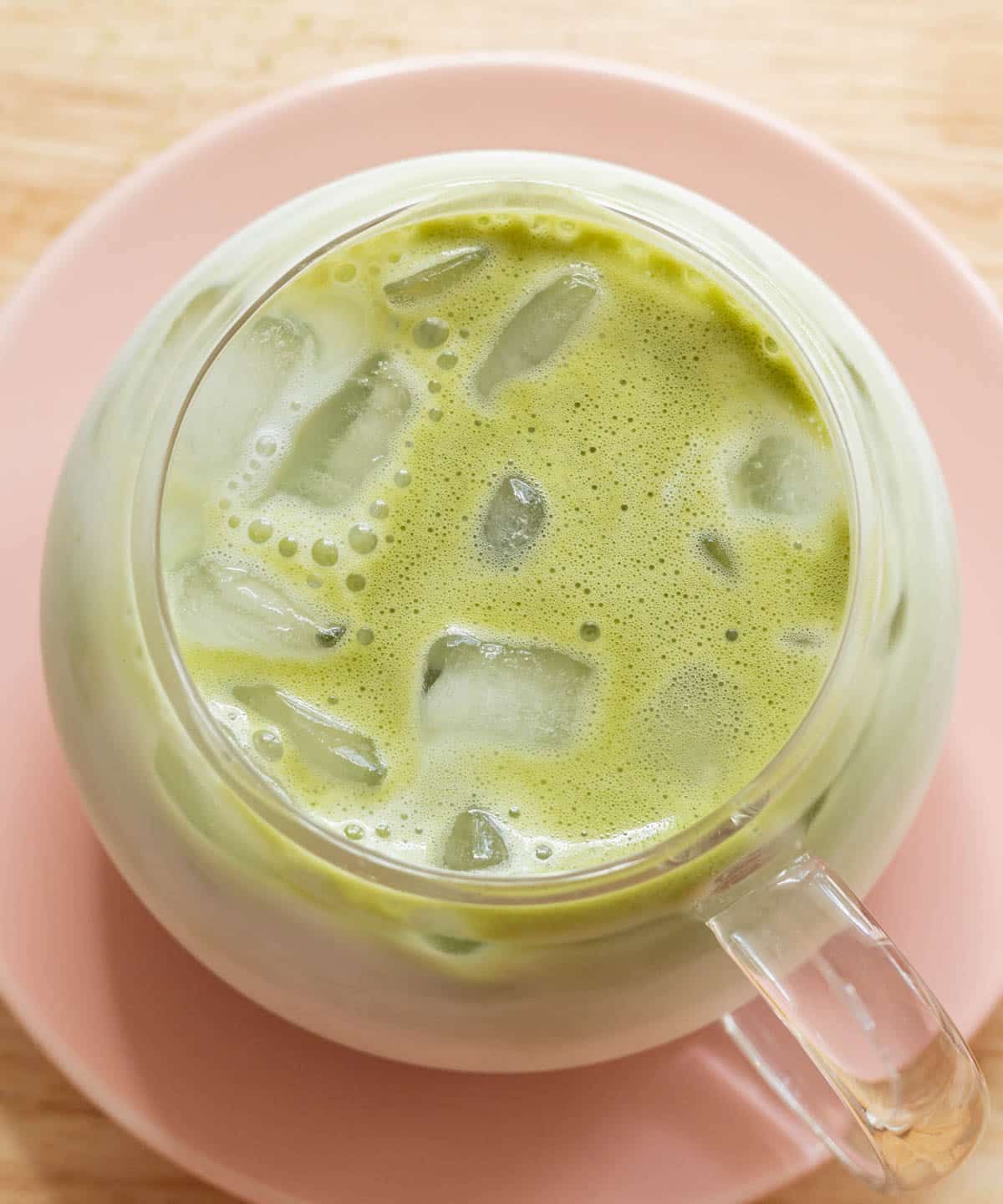 Birds eye view of matcha latte in glass cup.