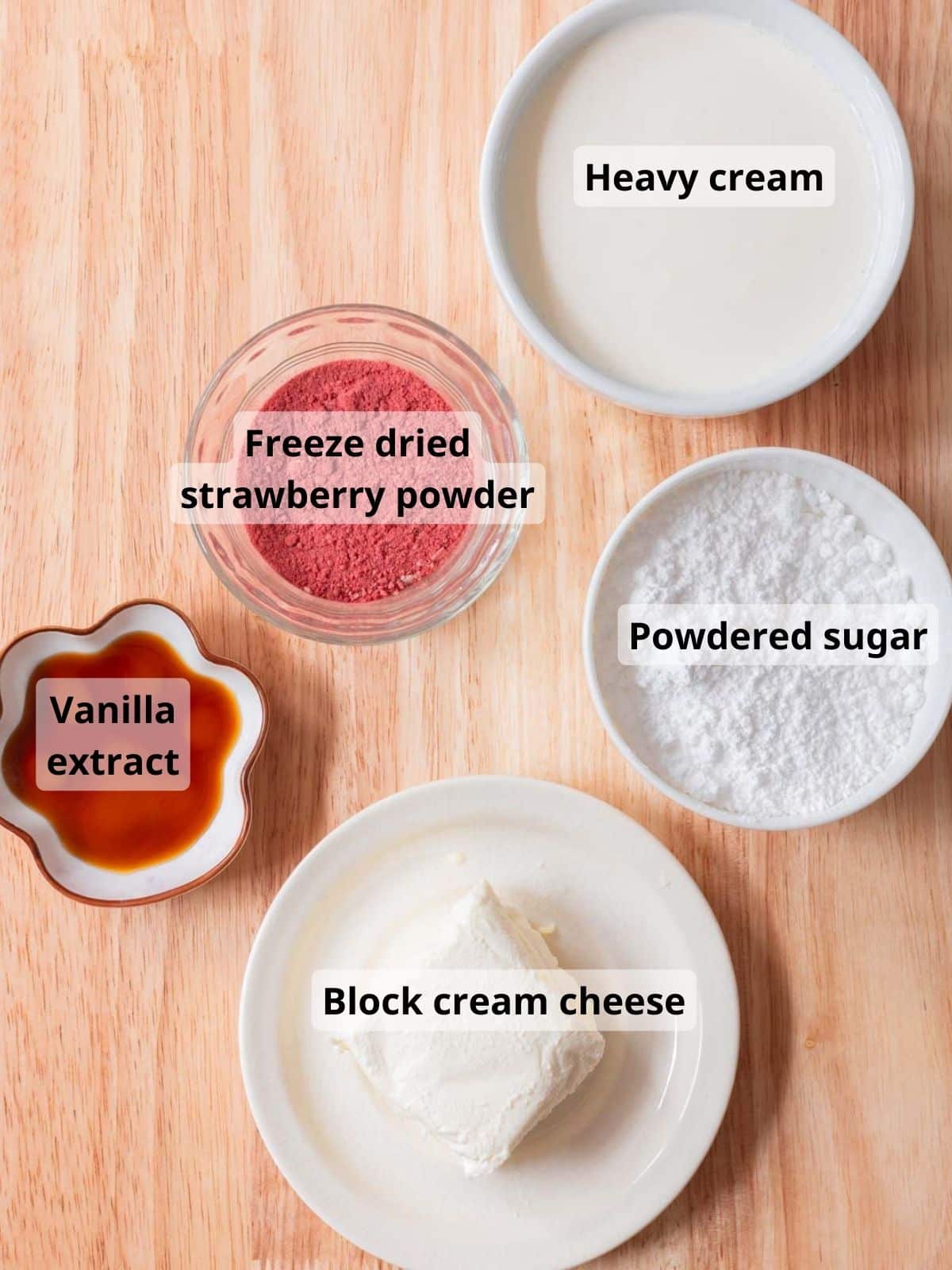 Stabilized freeze dried strawberry whipped cream frosting labeled ingredients laid out on a wooden table.