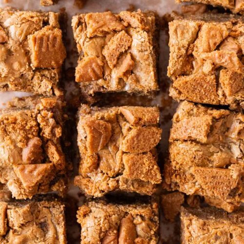 Freshly cut Biscoff blondies on top of parchment paper.