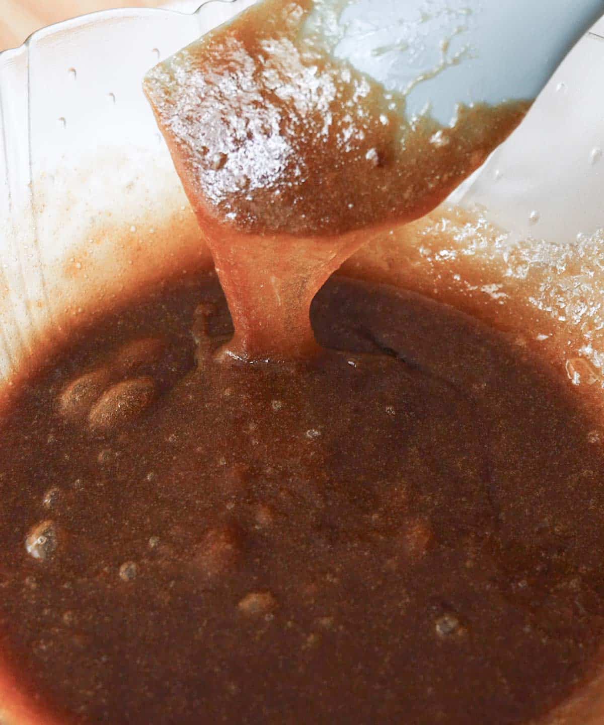 Glass mixing bowl with Biscoff blondie wet ingredients fully combined.