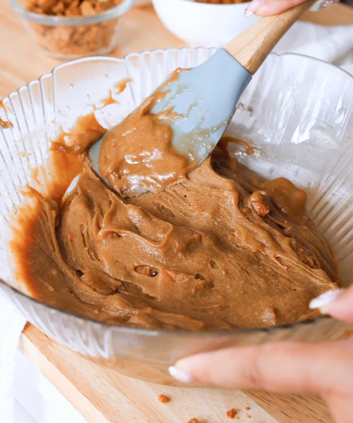 Glass mixing bowl with finished glossy cookie butter blondie batter.