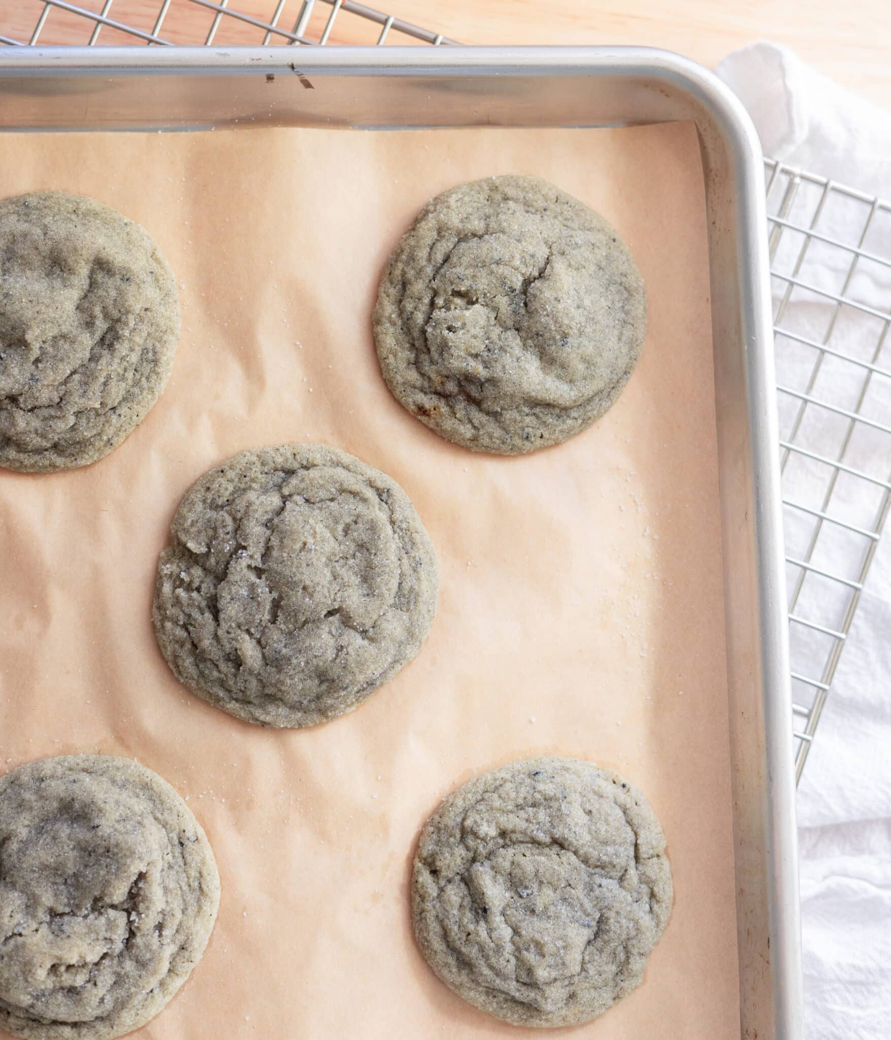 Baked black sesame sugar cookies on a lined cookie sheet.