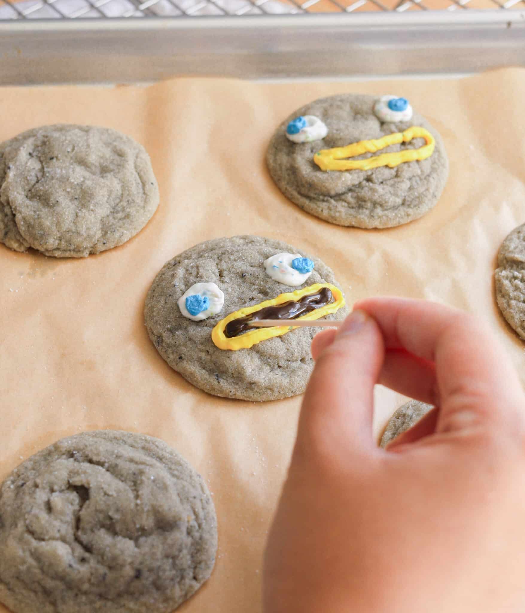 Decorating black sesame sugar cookies into rocks from Over the Garden Wall.
