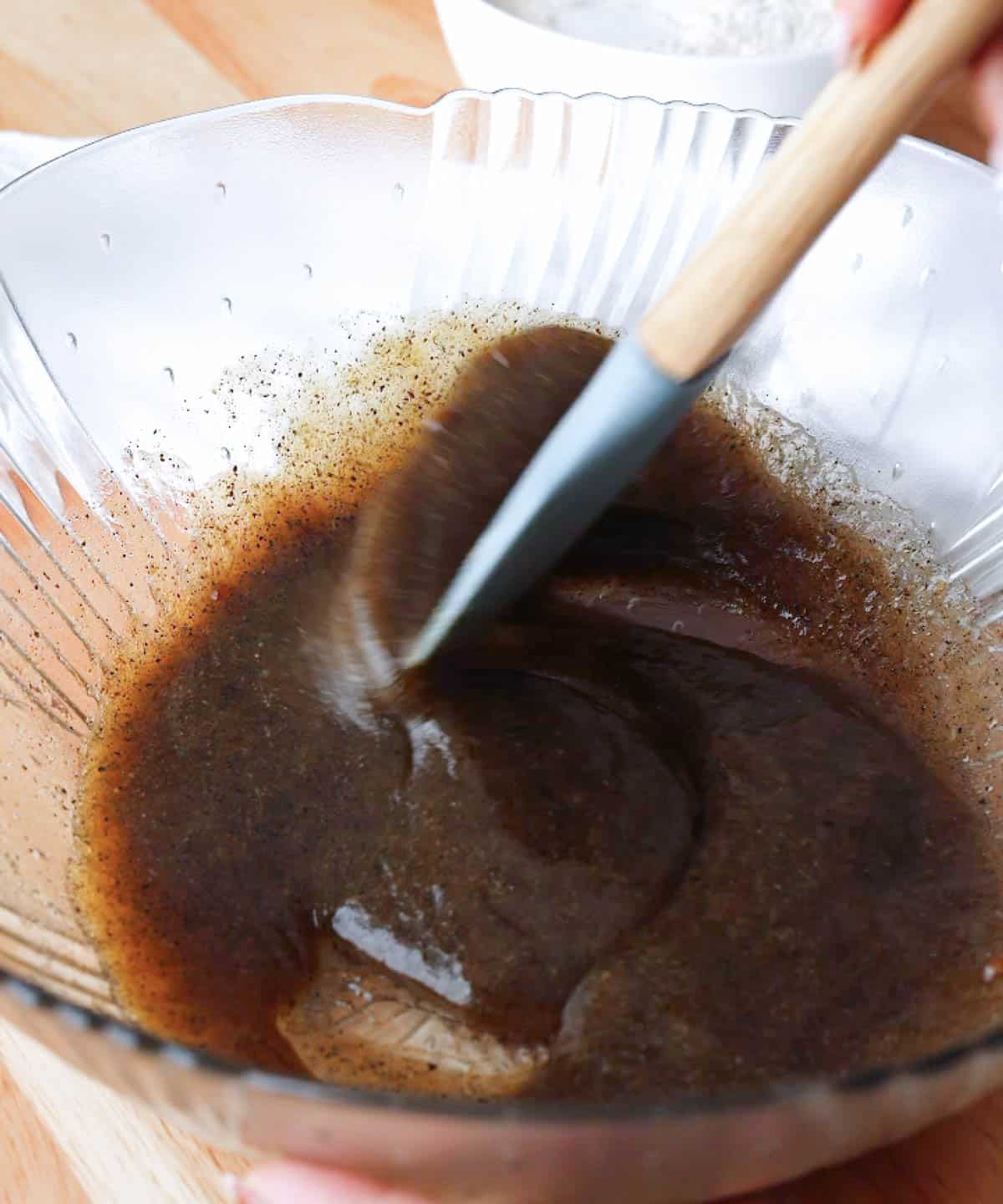 Stirring in eggs and vanilla into glass mixing bowl.