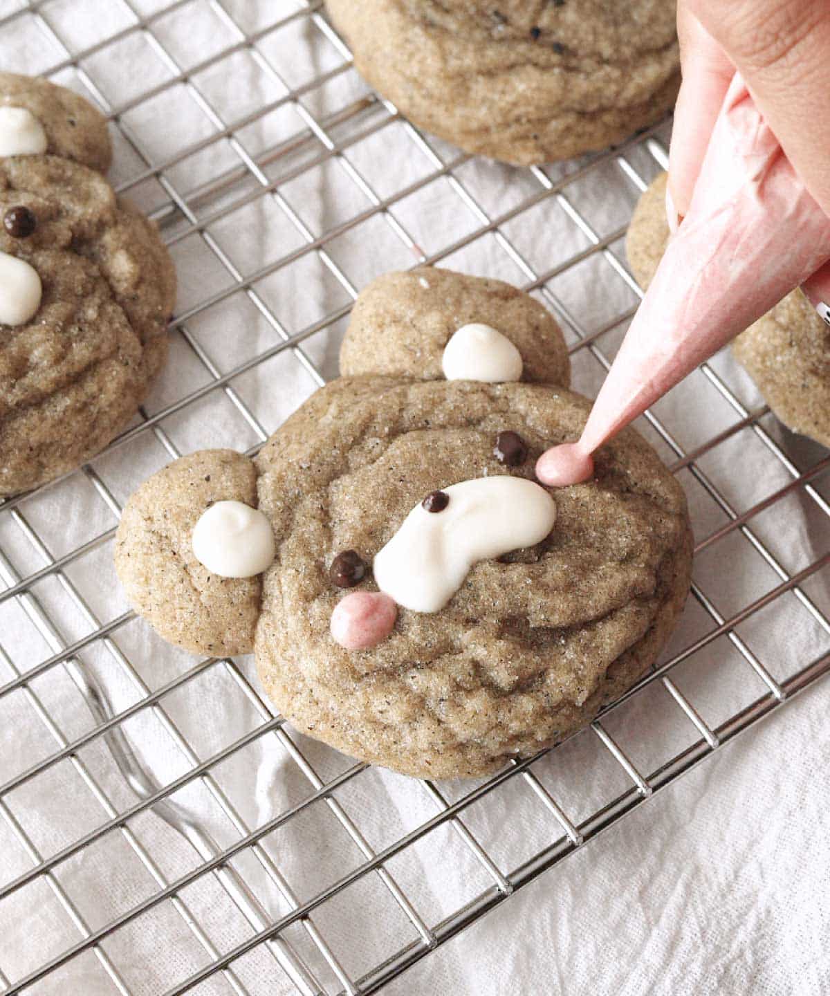 Decorating bear cookies with melted chocolates.