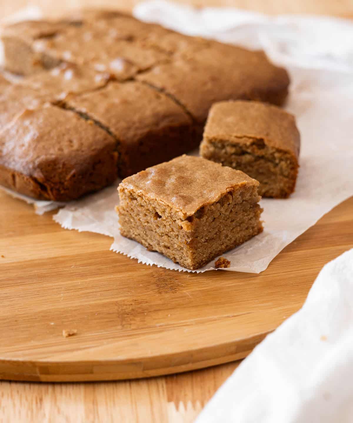 Square blondie bar on top of white parchment paper.