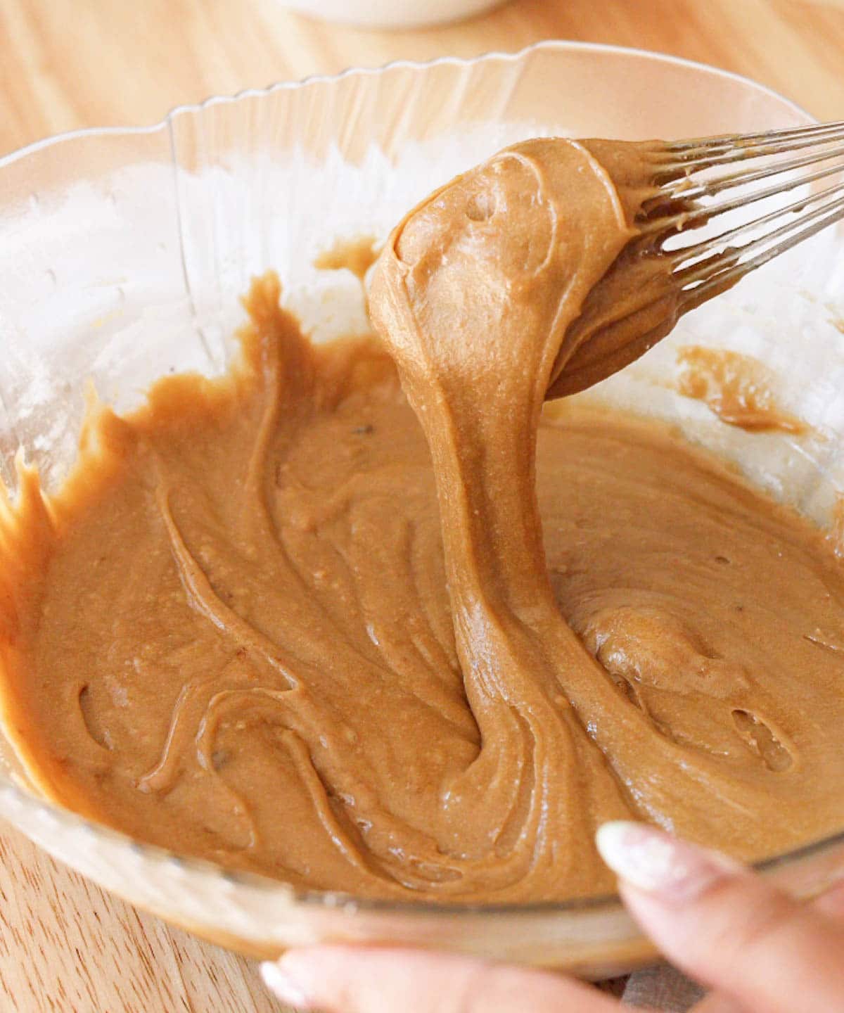 Glass mixing bowl with finished glossy blondie batter.