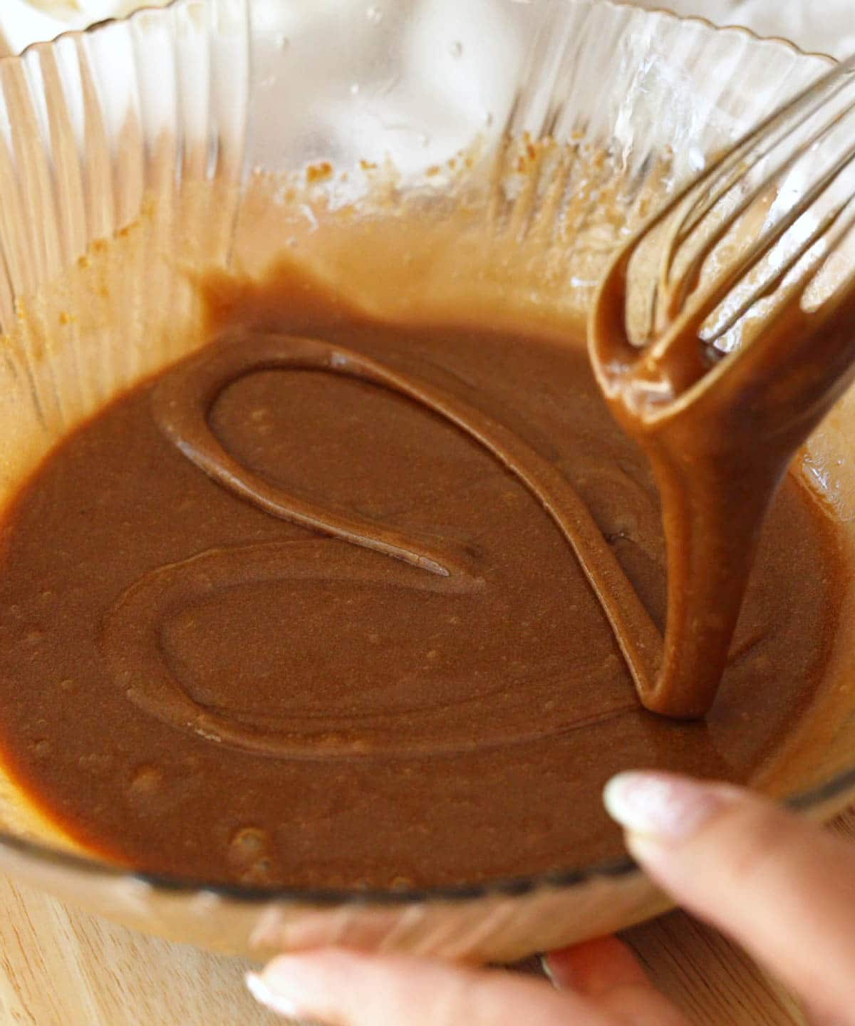 Glass mixing bowl with wet ingredients thoroughly mixed together. 