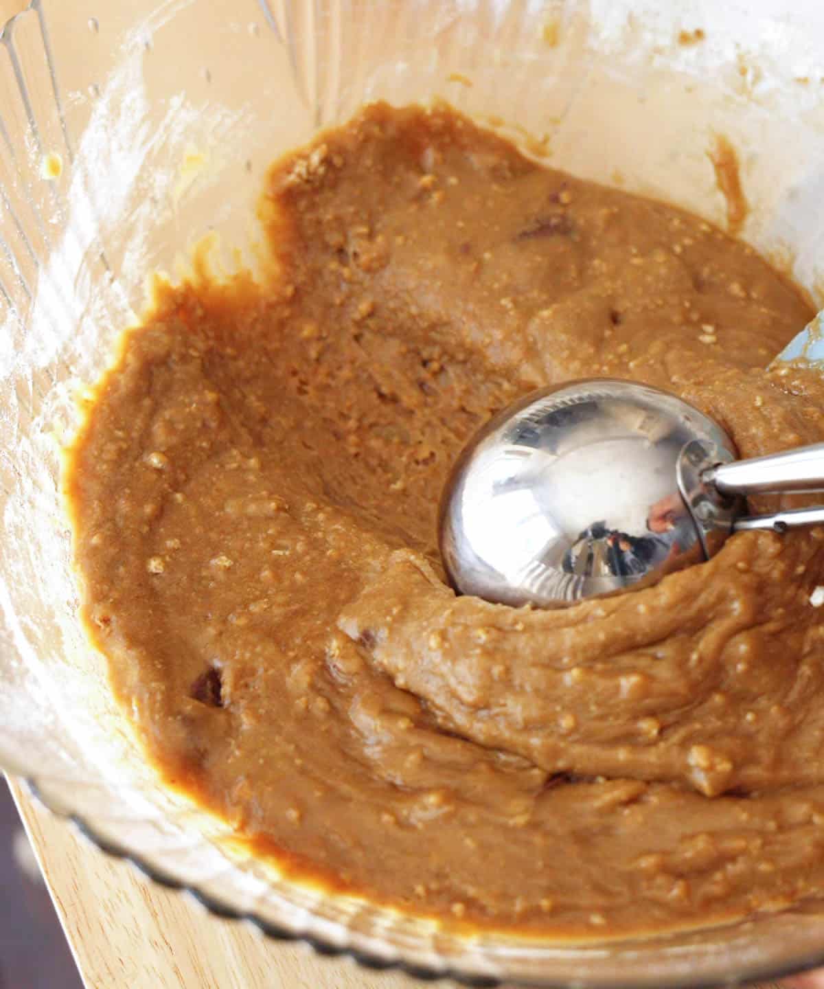 Using a large scoop to gather blondie batter.