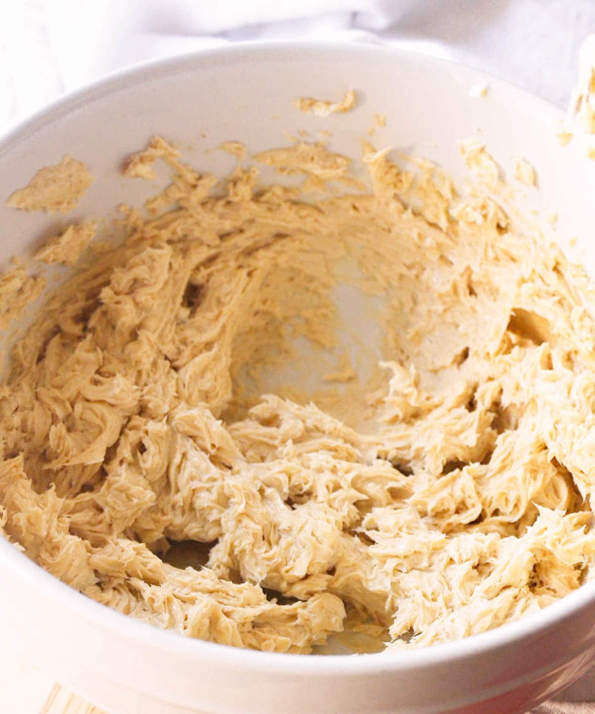 Whipped brown sugar butter in a white mixing bowl.