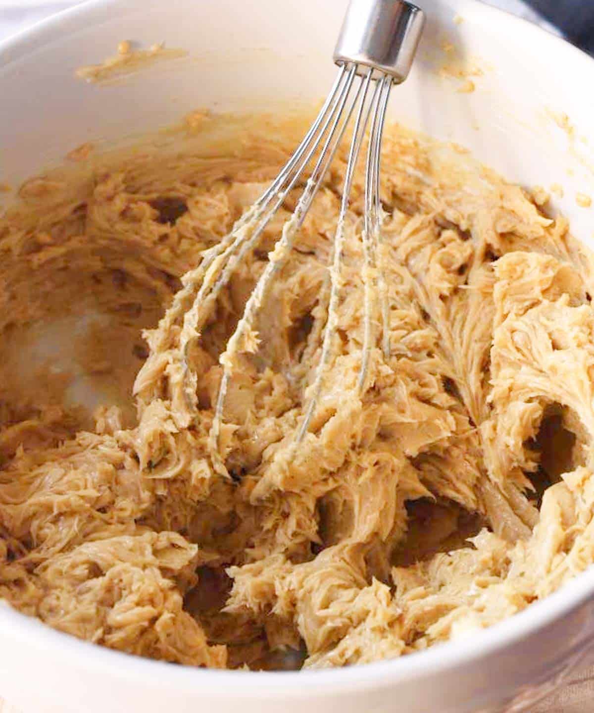 Whipped maple syrup butter in a white mixing bowl.