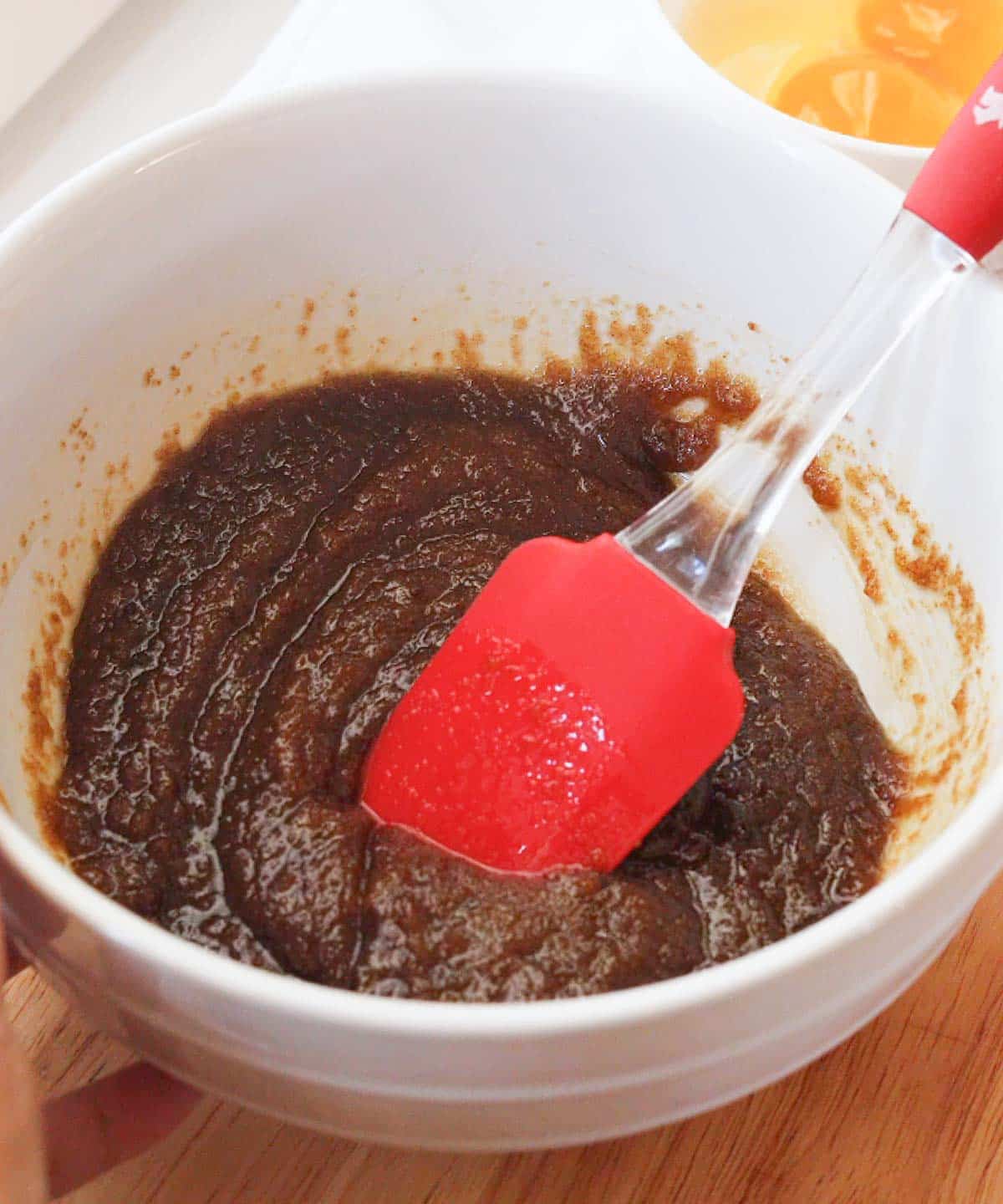 Melted butter mixed with sugars in white mixing bowl.