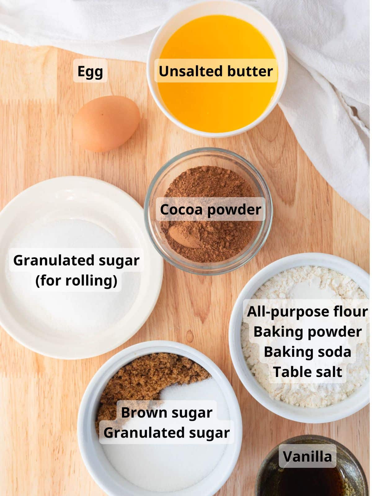 Chocolate sugar cookie ingredients laid out on a table with labels.