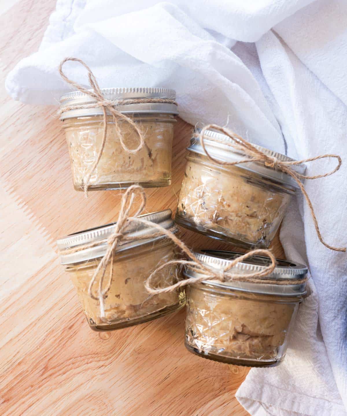 Homemade cinnamon honey butter in jars wrapped with twine. 