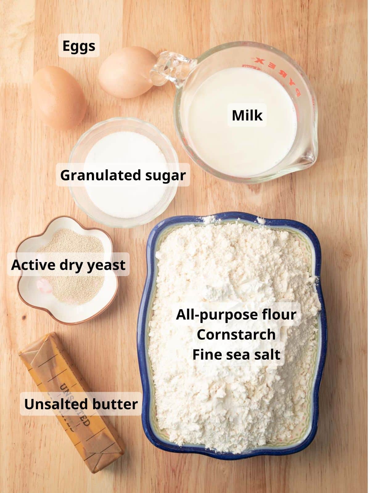 Labeled cinnamon roll dough ingredients laid out on a table.