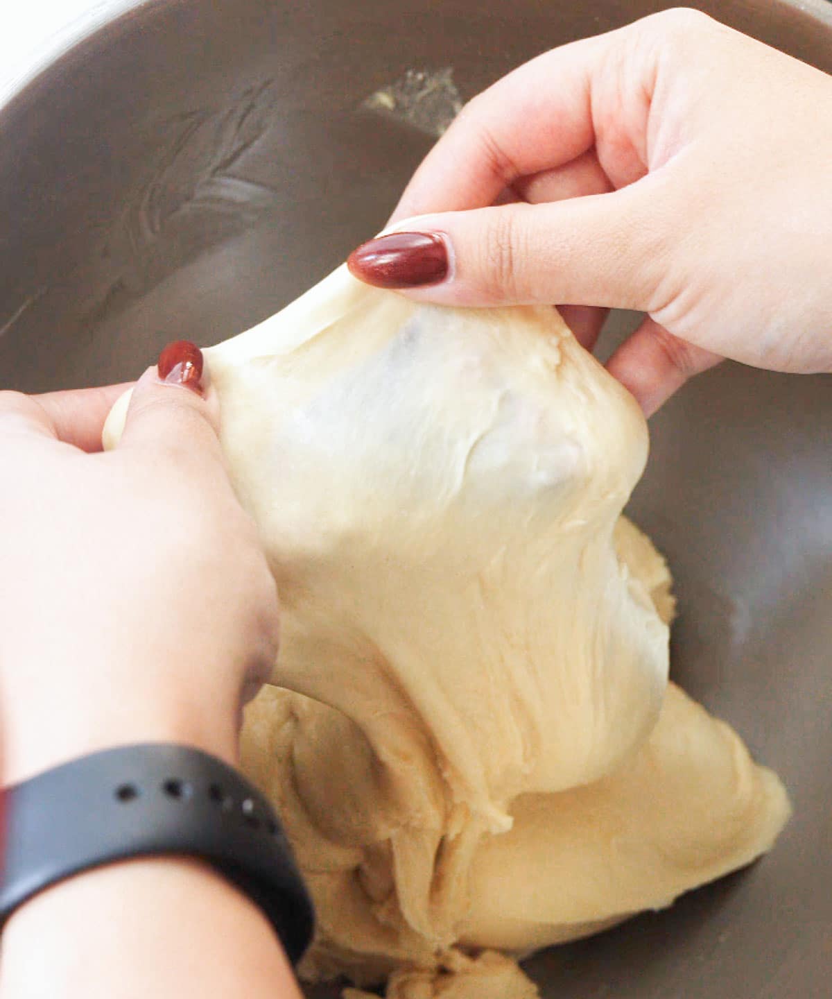 Cinnamon roll dough passing the window pane test.