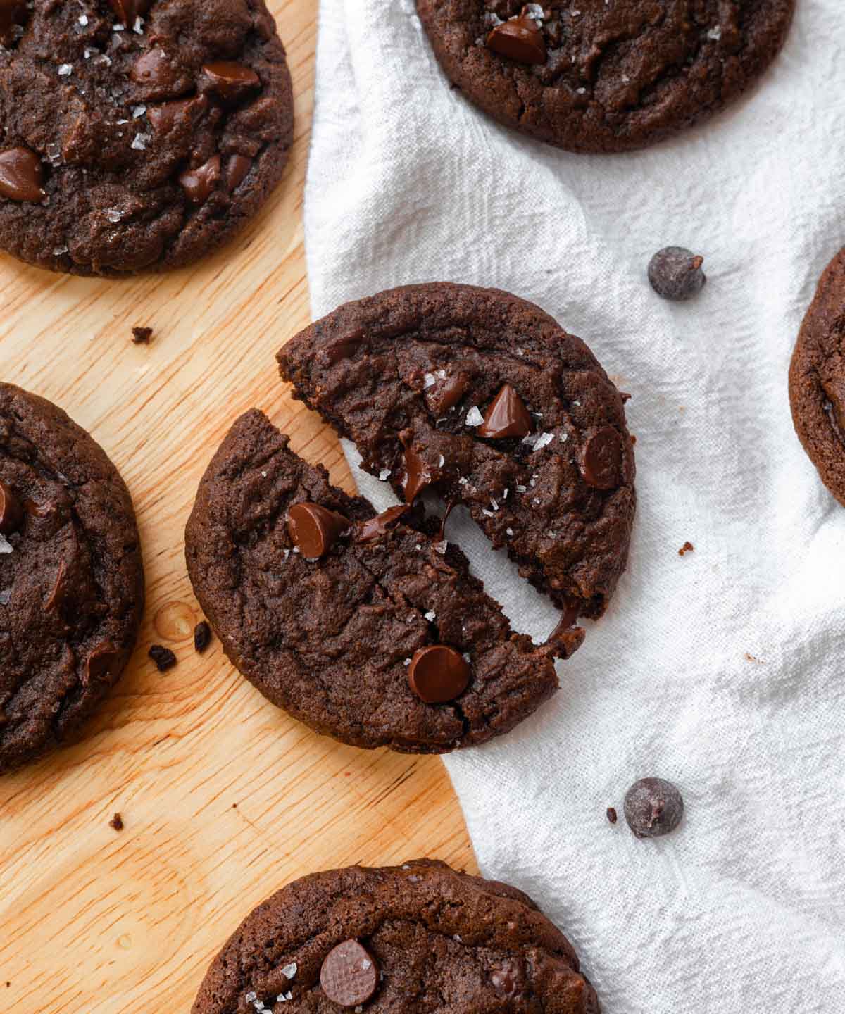 Double chocolate chip cookie ripped in half, showing gooey melted texture of the chocolate chips.