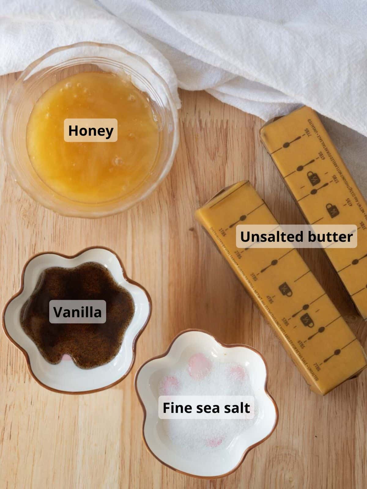 Labelled honey butter ingredients on a wooden table.