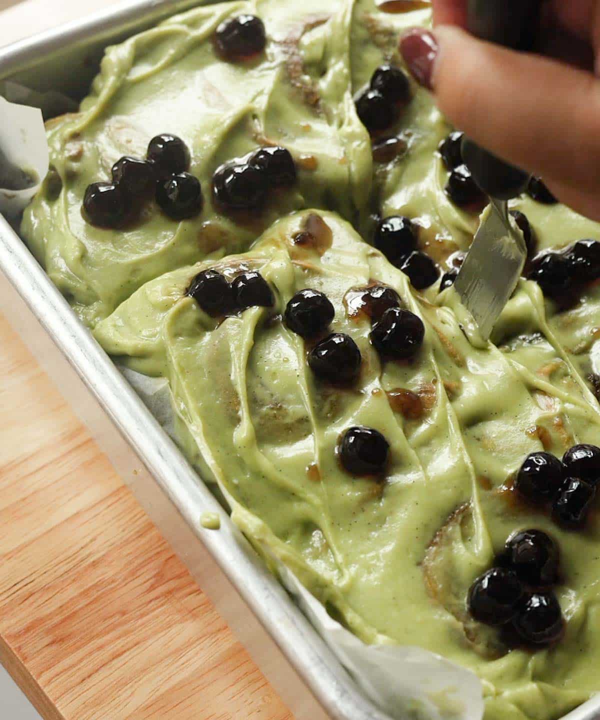 Taking boba matcha buns out of baking pan.