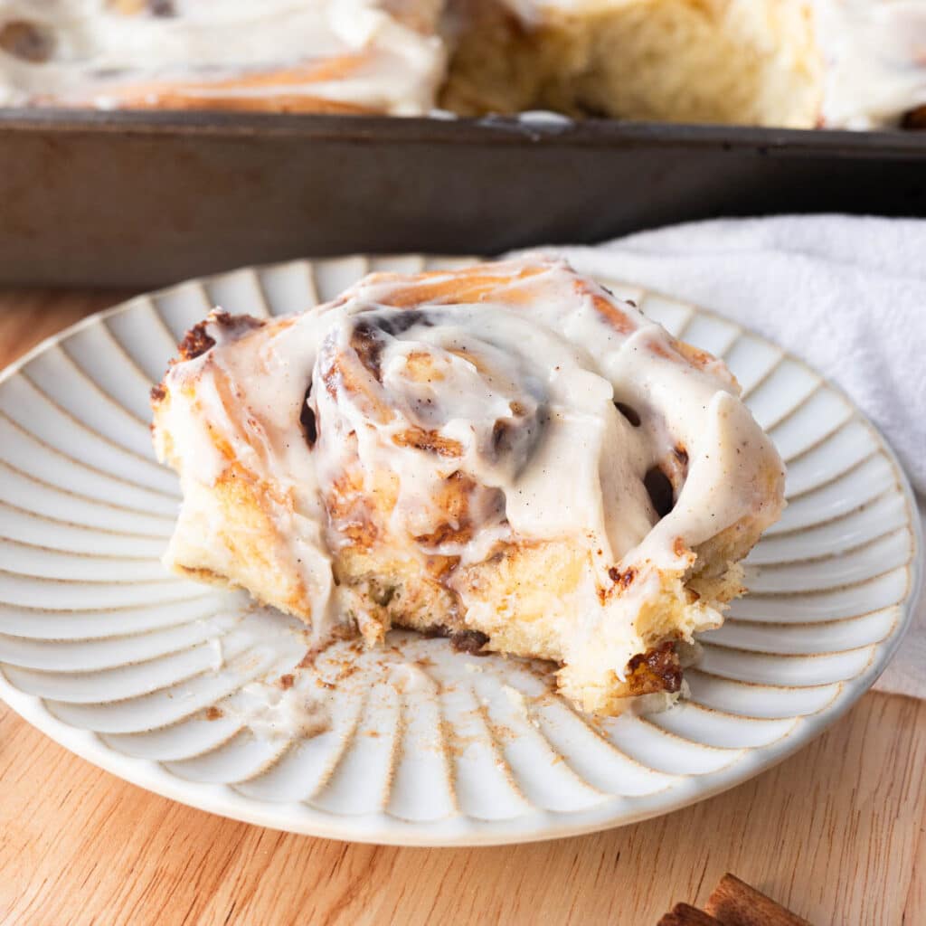 Cinnamon roll with a bite taken out of it.