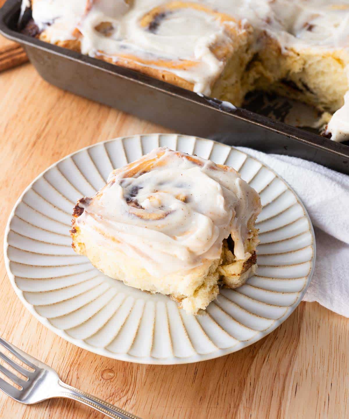 Cinnamon roll on a fluted plate.