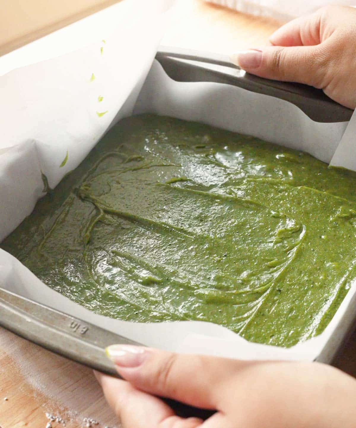 Matcha brownie batter in square pan ready to be baked.