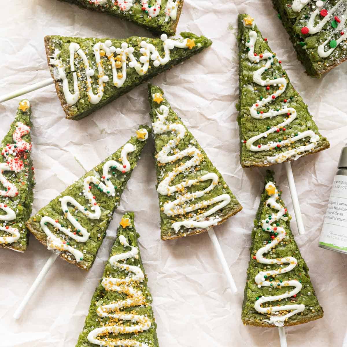 Matcha Christmas tree brownies decorated with white chocolate and sprinkles.