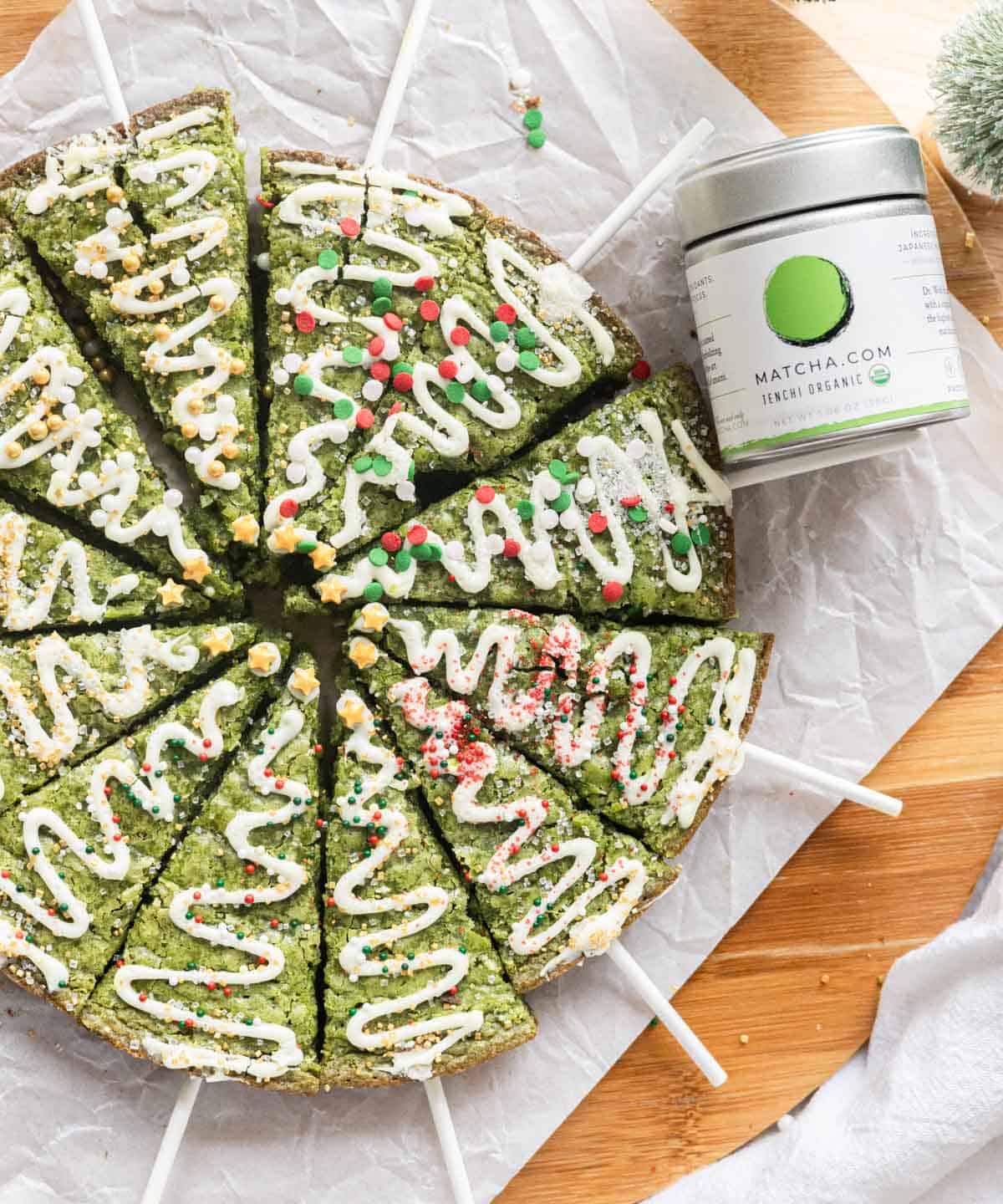 Matcha brownies decorated as Christmas trees using melted chocolate and sprinkles.