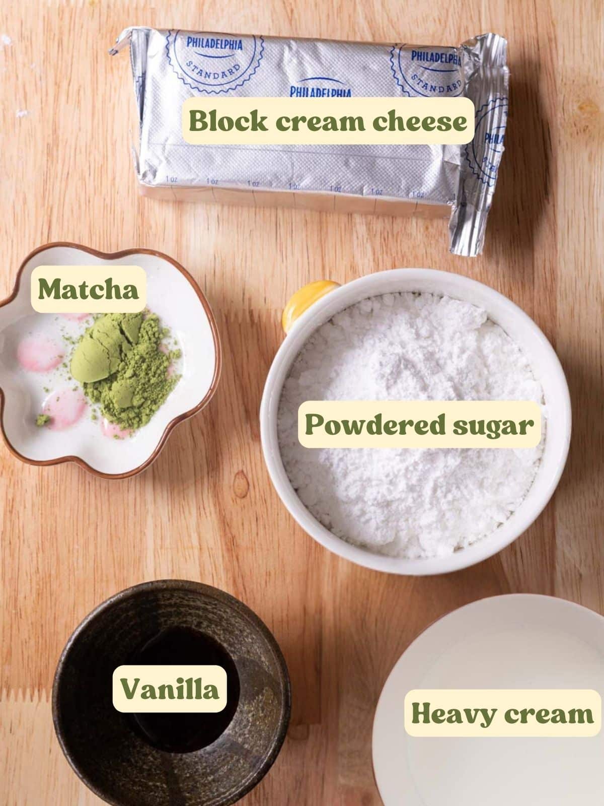 Matcha cream cheese frosting labeled ingredients on a wooden table.