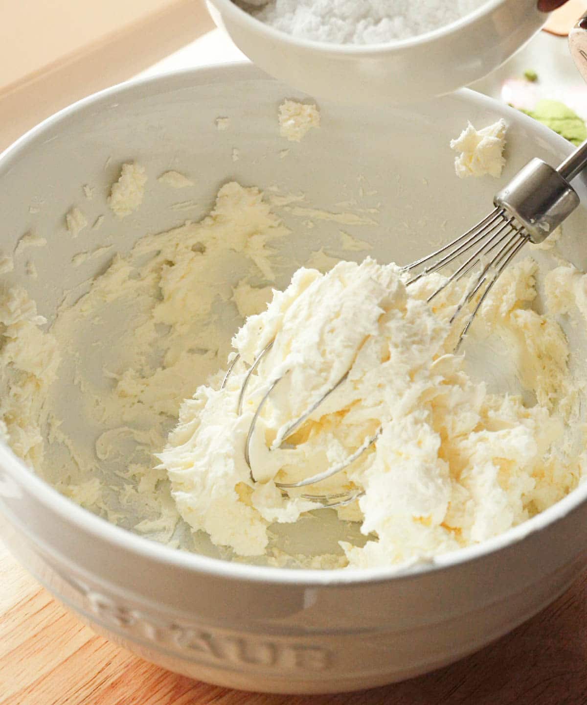 Whipped cream cheese in white mixing bowl.