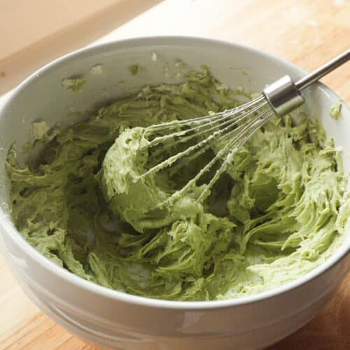 Fluffy matcha cream cheese frosting in a white mixing bowl.