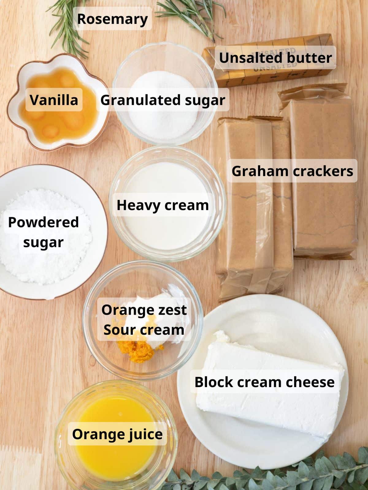 No-bake orange cheesecake labeled ingredients on a wooden table.