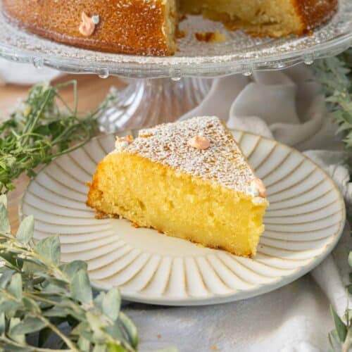 Slice of orange olive oil cake on a fluted plate.