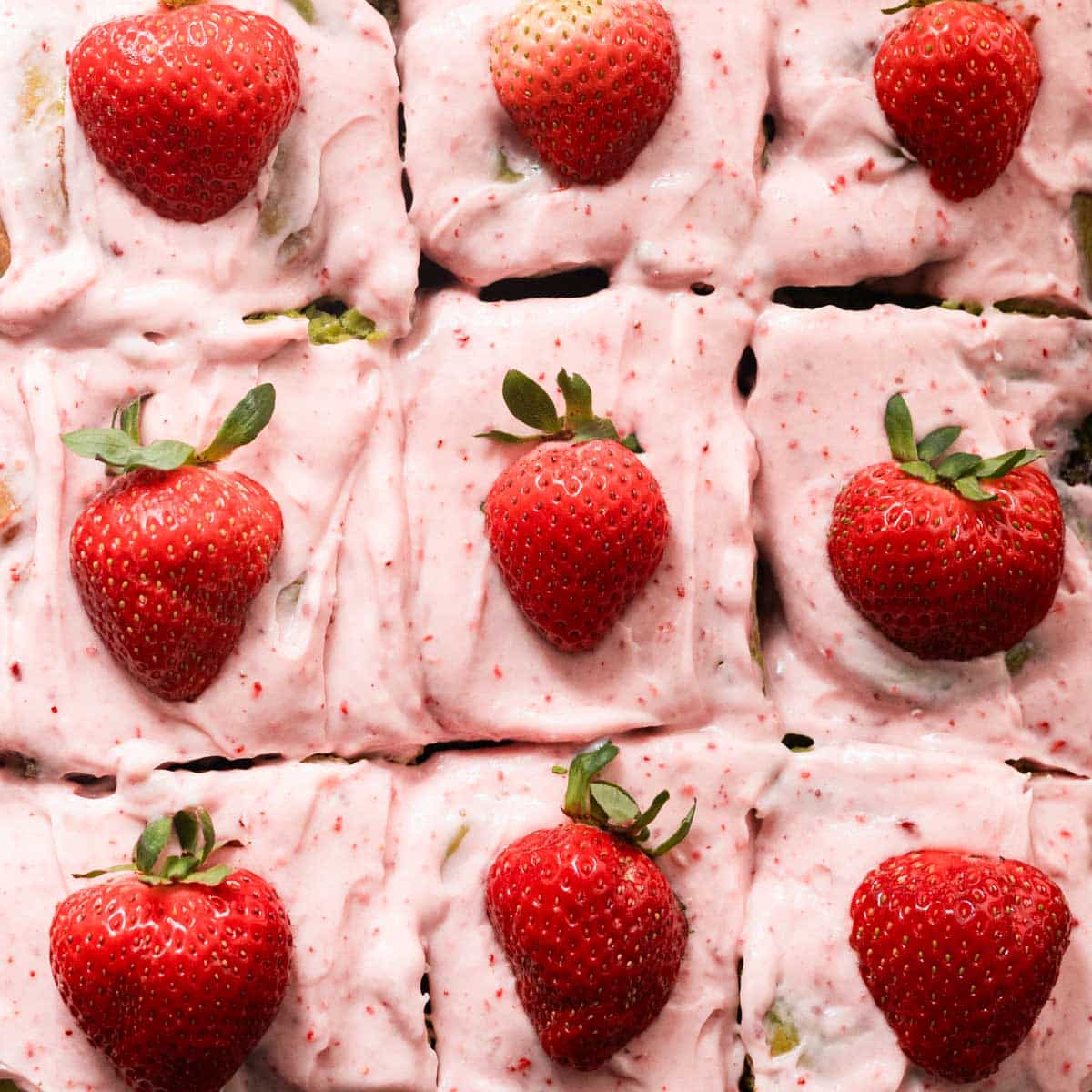 Sliced strawberry matcha rolls in a rectangular baking pan.