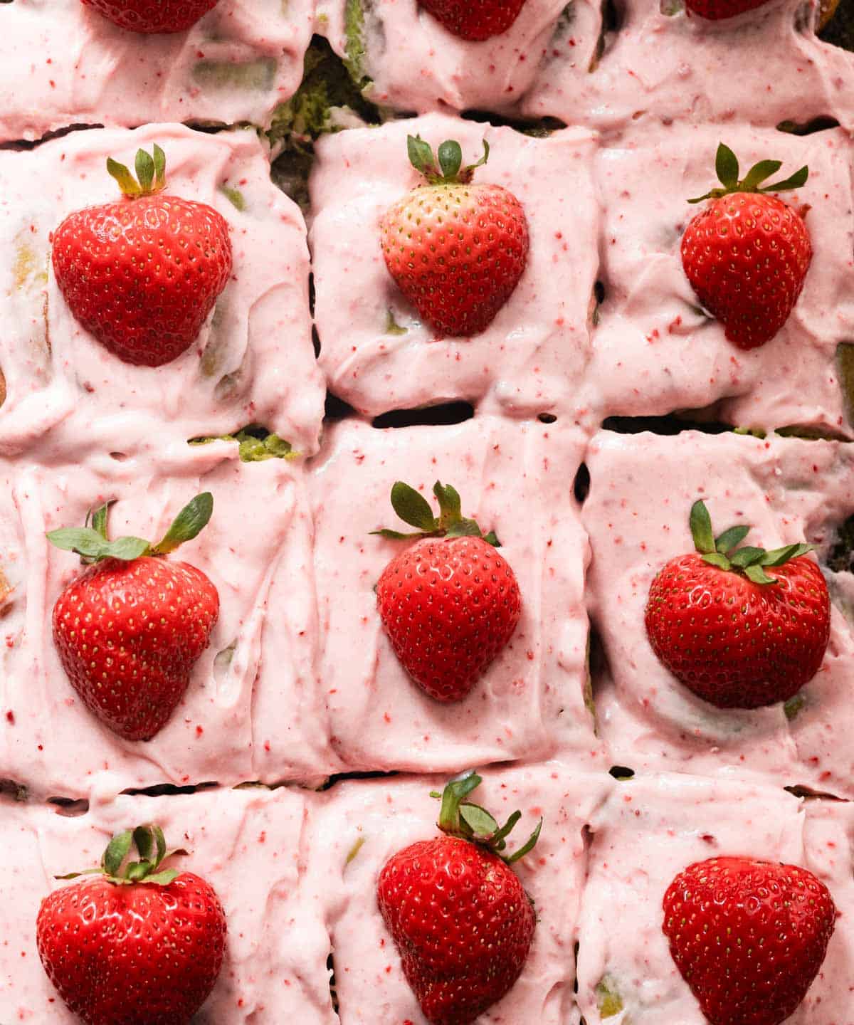 Sliced strawberry matcha rolls in a rectangular baking pan.