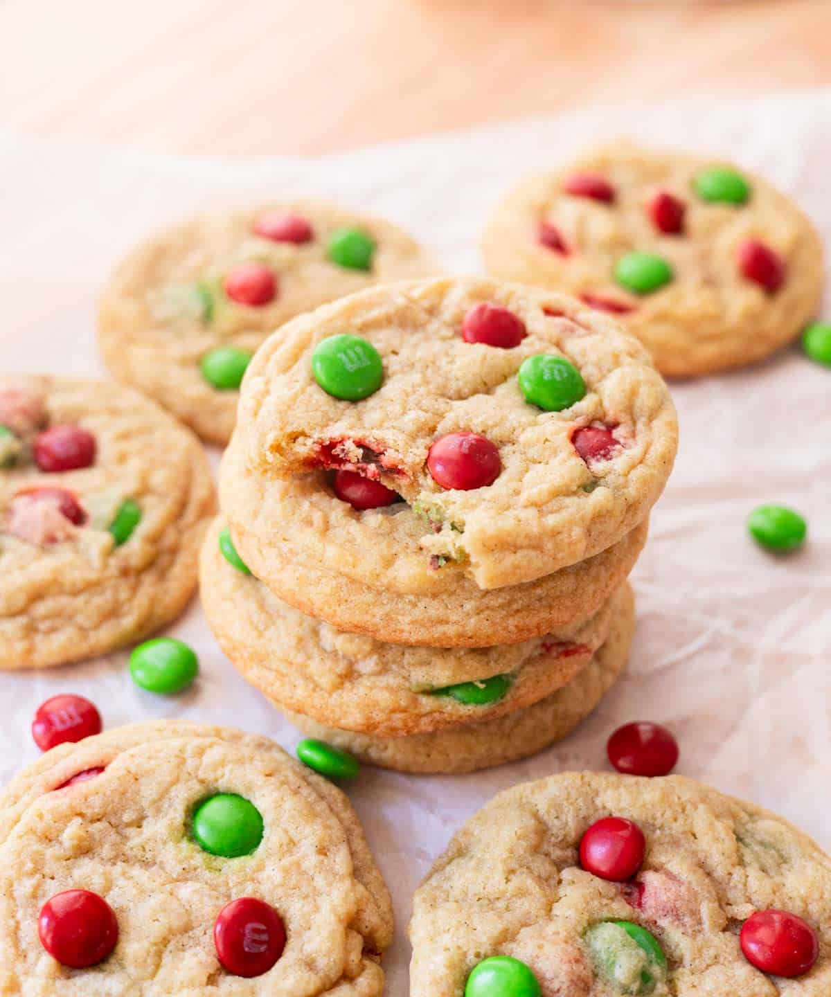 Stacked Christmas M&M cookies on parchment paper.