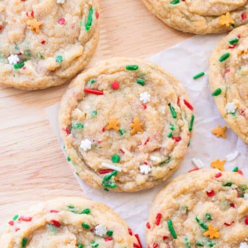 Cute gingerbread Christmas sprinkle cookies on wooden table.