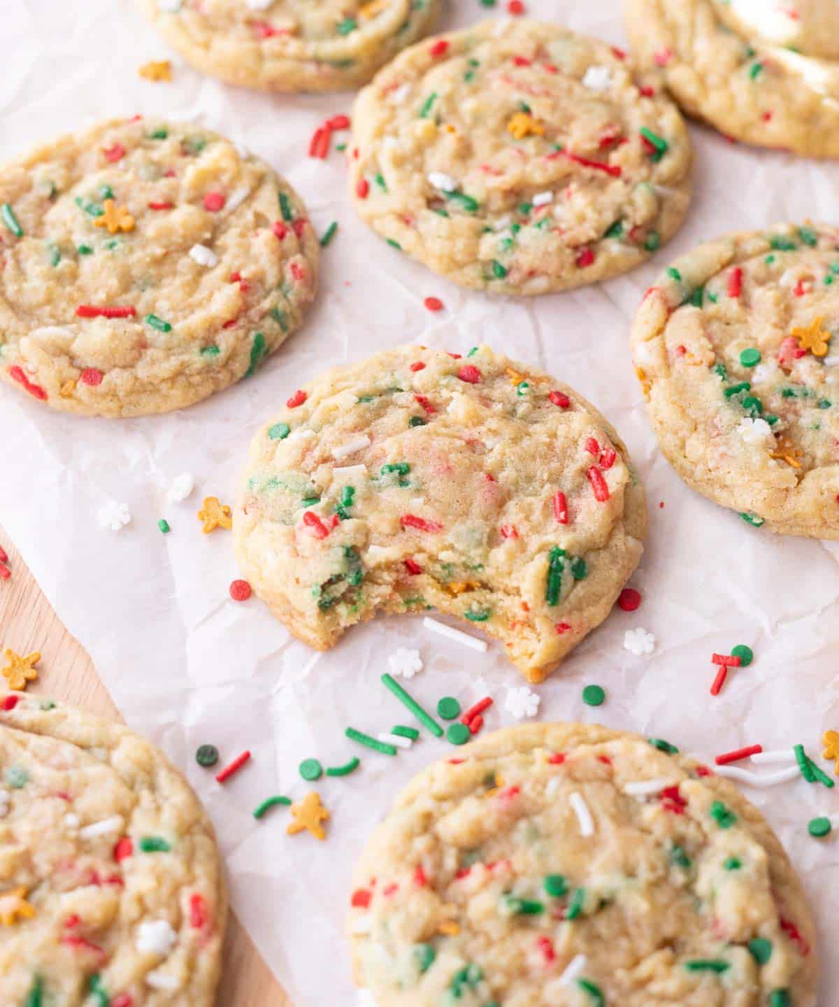 Cute Christmas sprinkle cookies; one has a bite taken out of it.