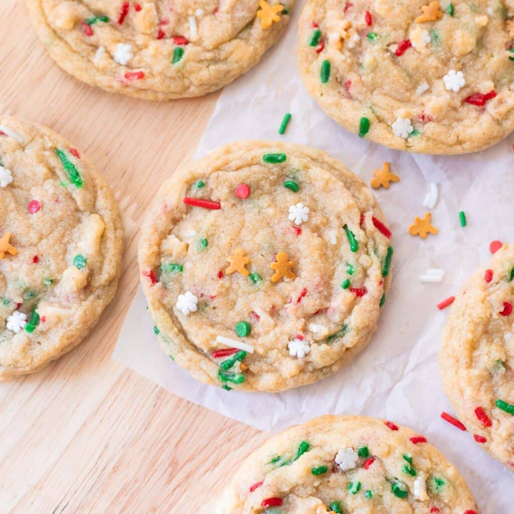 Cute red and green Christmas sprinkle cookies on parchment paper.