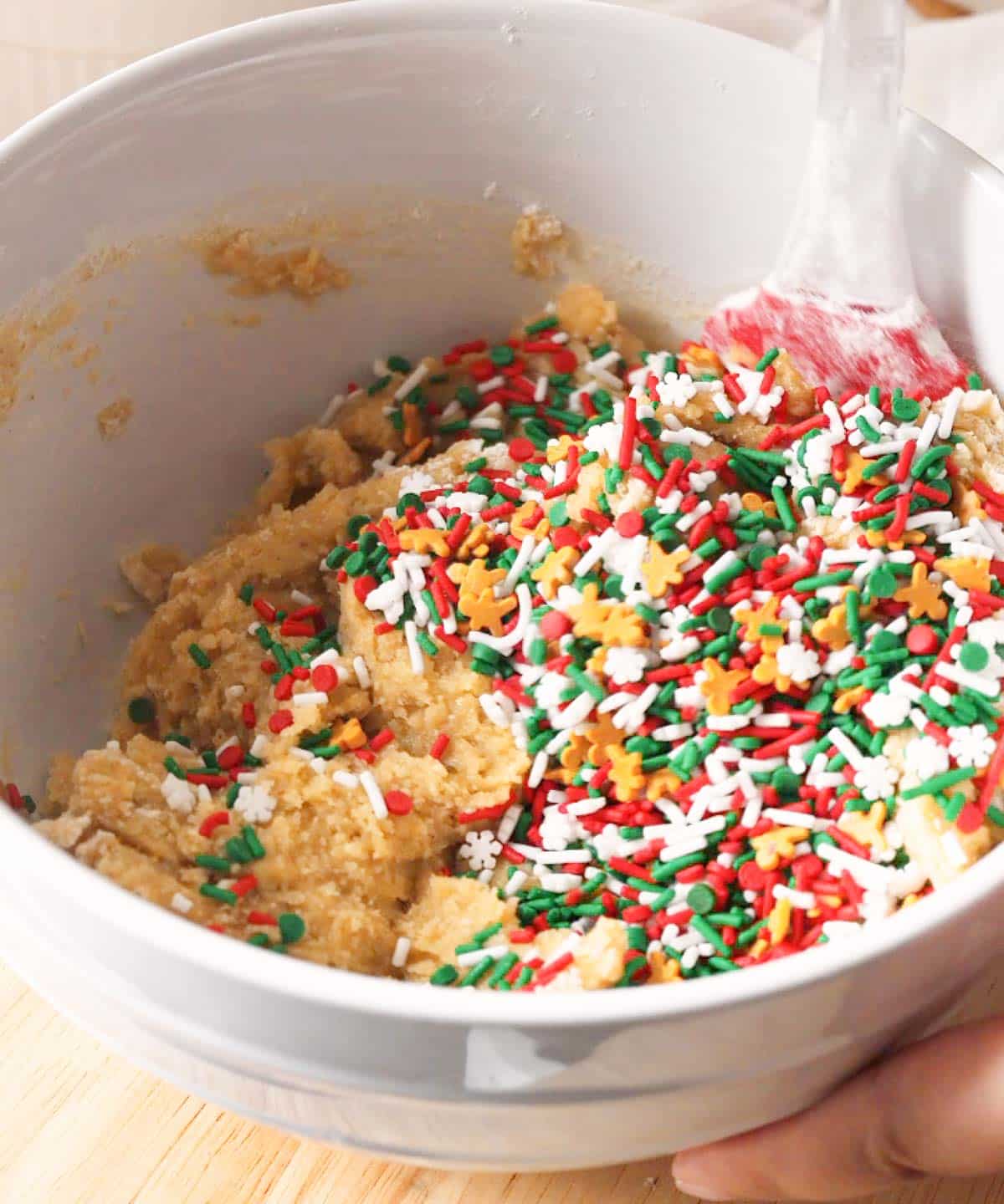 Christmas sprinkles poured on top of cookie dough batter.