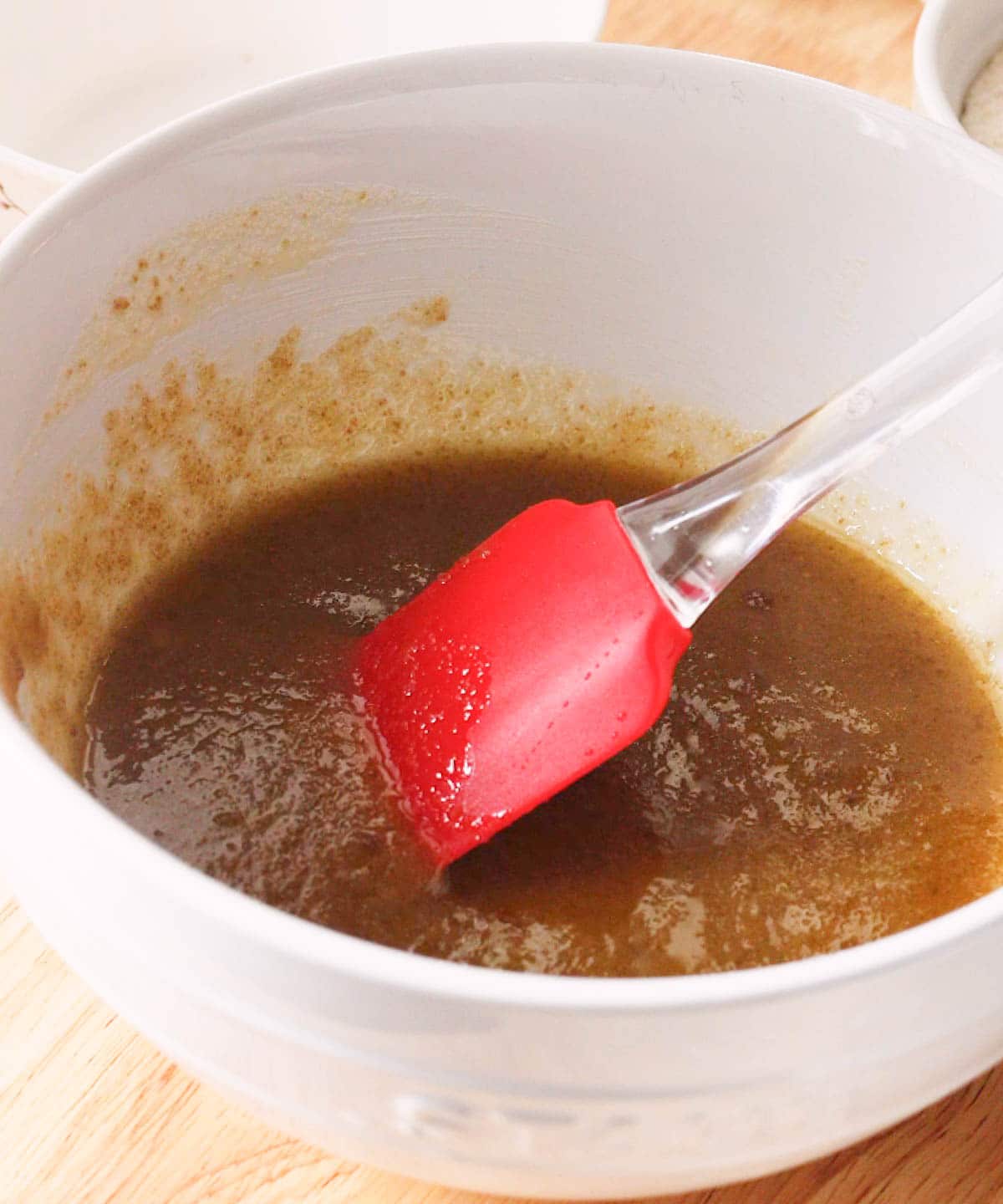 Melted butter mixed with sugars in white mixing bowl.