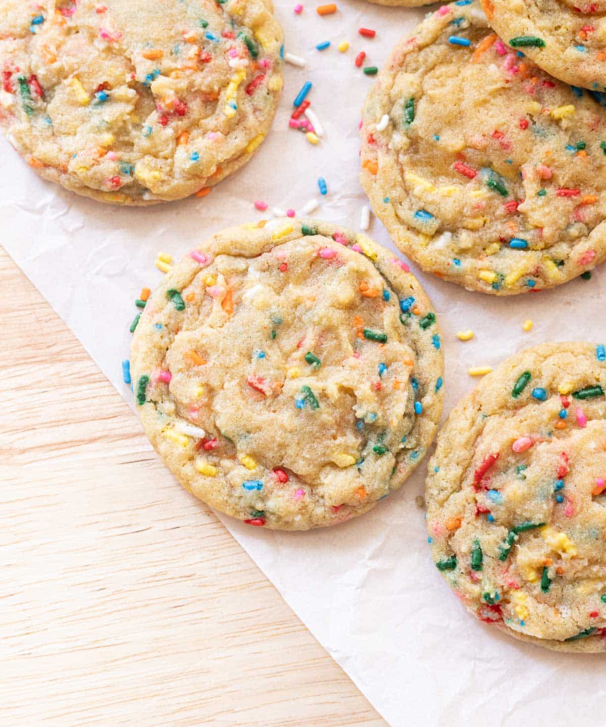 Funfetti cookies on white parchment paper.