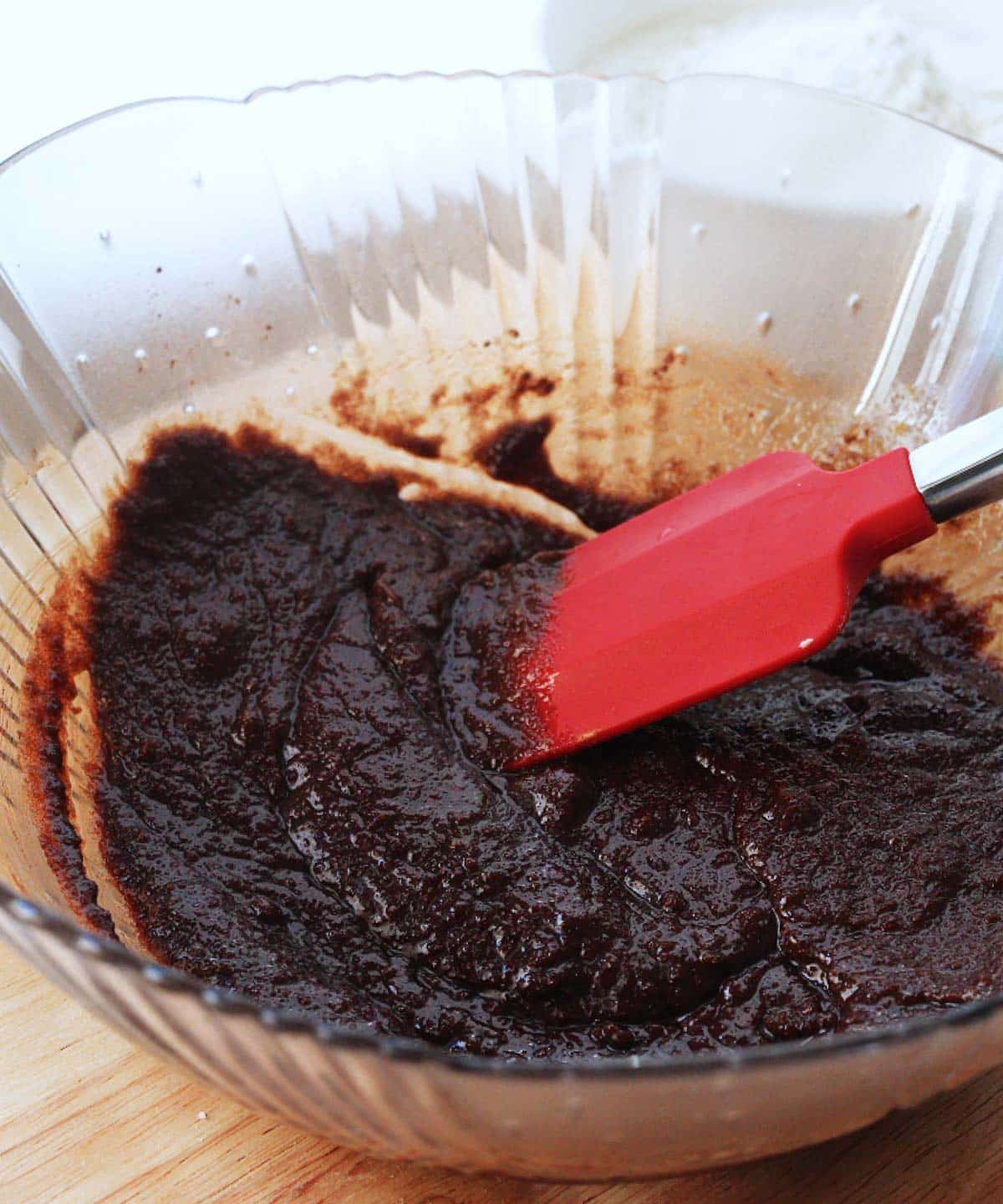 Mixed butter, sugars, and cocoa powder in a glass bowl.