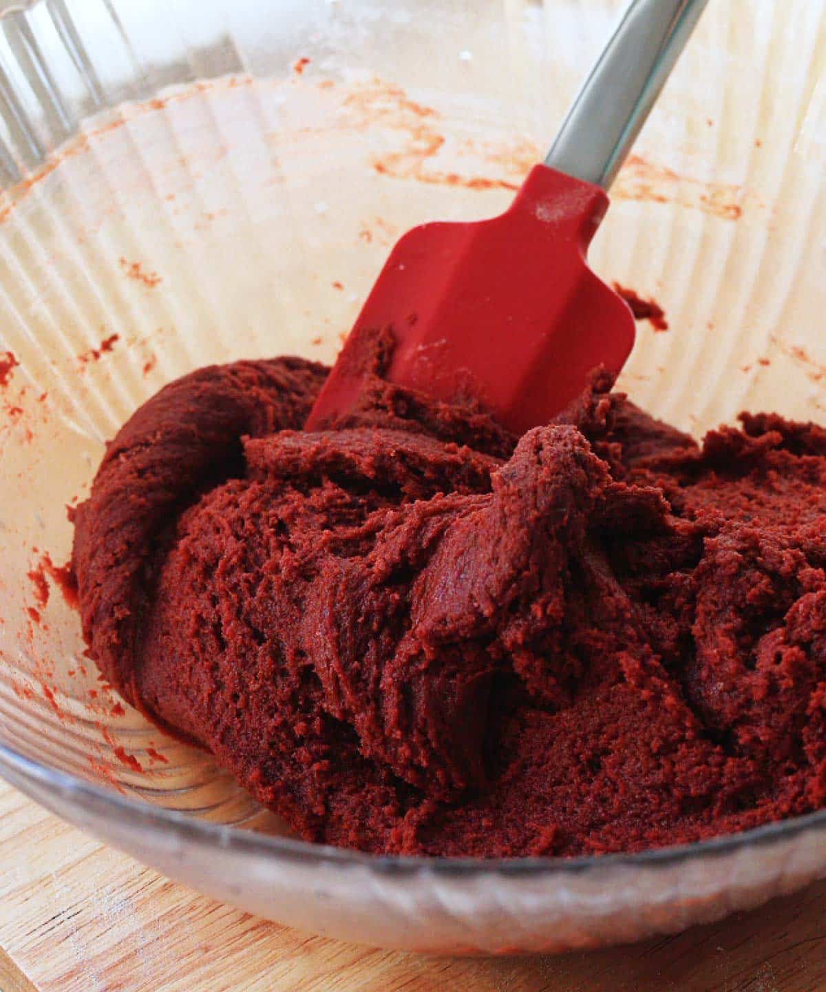 Red velvet cookie dough ready to be scooped and rolled.